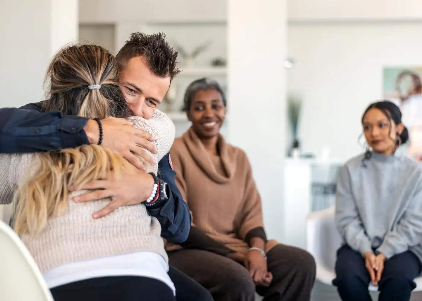 A man embraces a woman in a waiting room during Methamphetamine Addiction Treatment