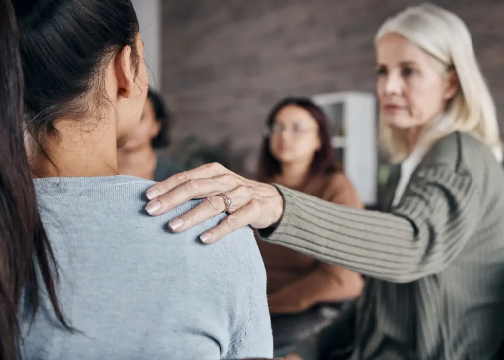 A woman engages in conversation with another during a meeting during treatment for heroin and opioid abuse at 10 Acre Ranch