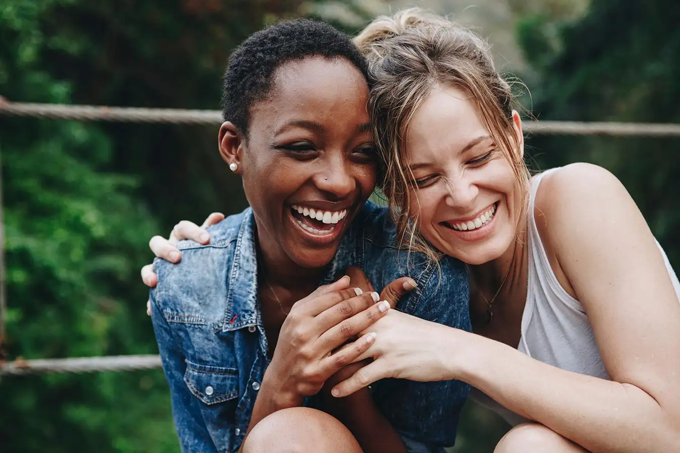 In a drug rehab center, two women smile and hug, showcasing their friendship and support during recovery