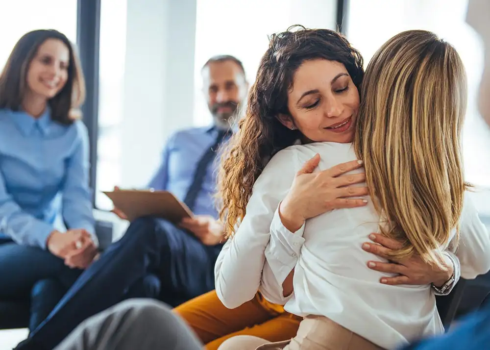 Two women embracing each other during  OxyContin addiction treatment.