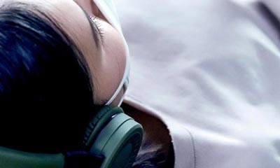 a female wearing headset lying down during a biosound therapy