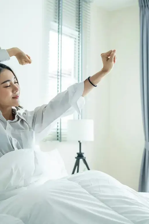 a woman stretching in bed embracing a peaceful morning routine