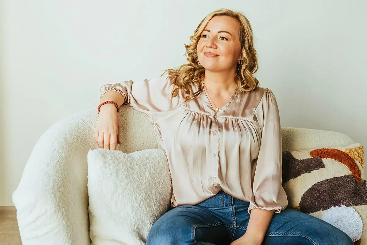 a happy woman sitting on a sofa
