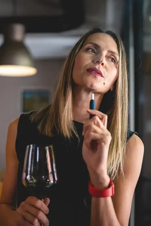 one woman with glass of red wine and electronic cigarette device