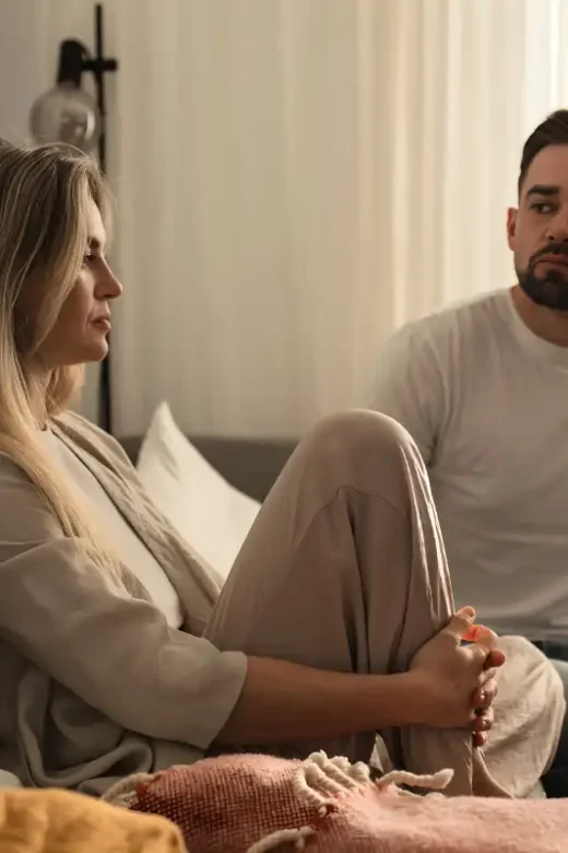 Couple Having Serious Conversation on Sofa in Tense Atmosphere