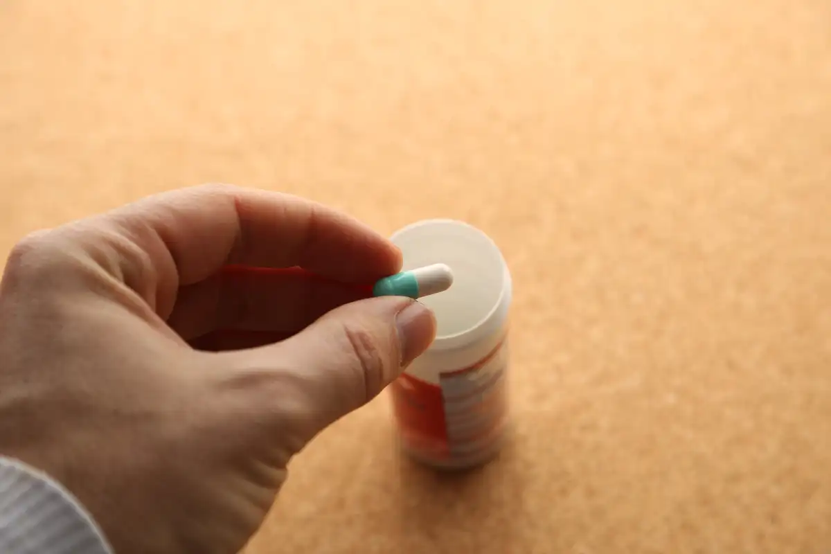 Hand holding an opioid pill. Medical drug addiction concept photo