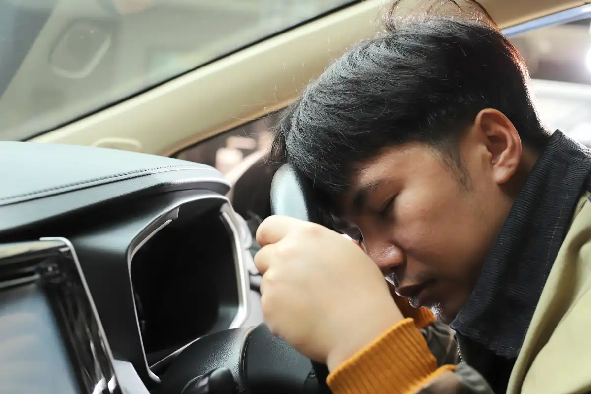 man driving a car suffering from extreme drowsiness