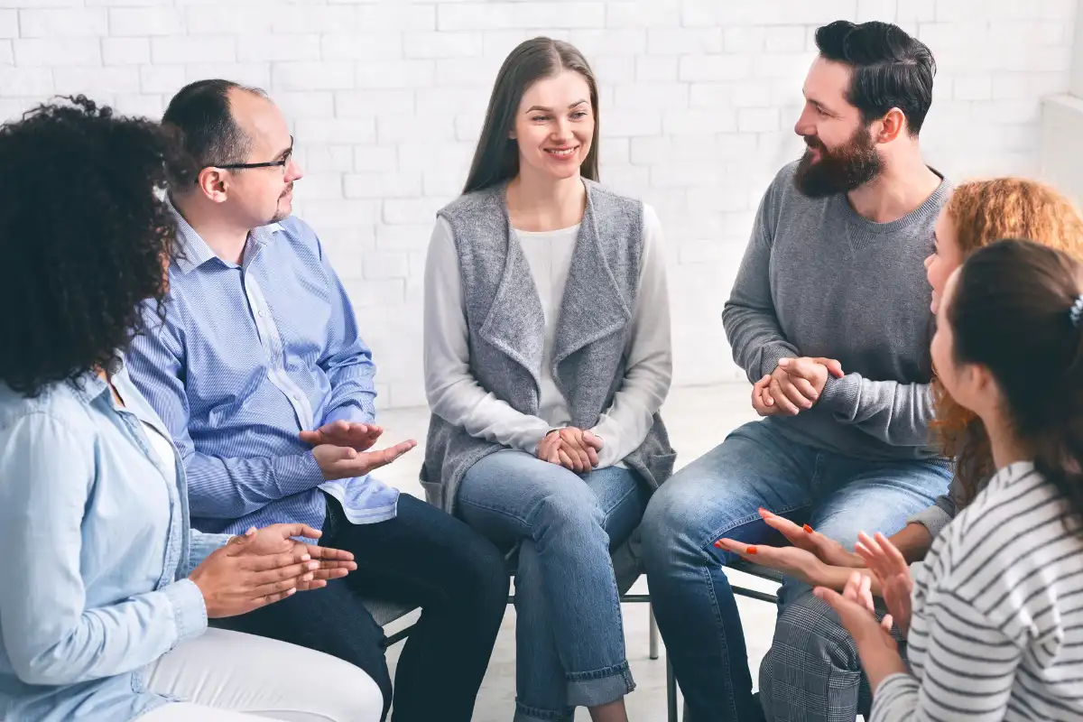 Community Members Applauding To Mentor At Session In Rehab