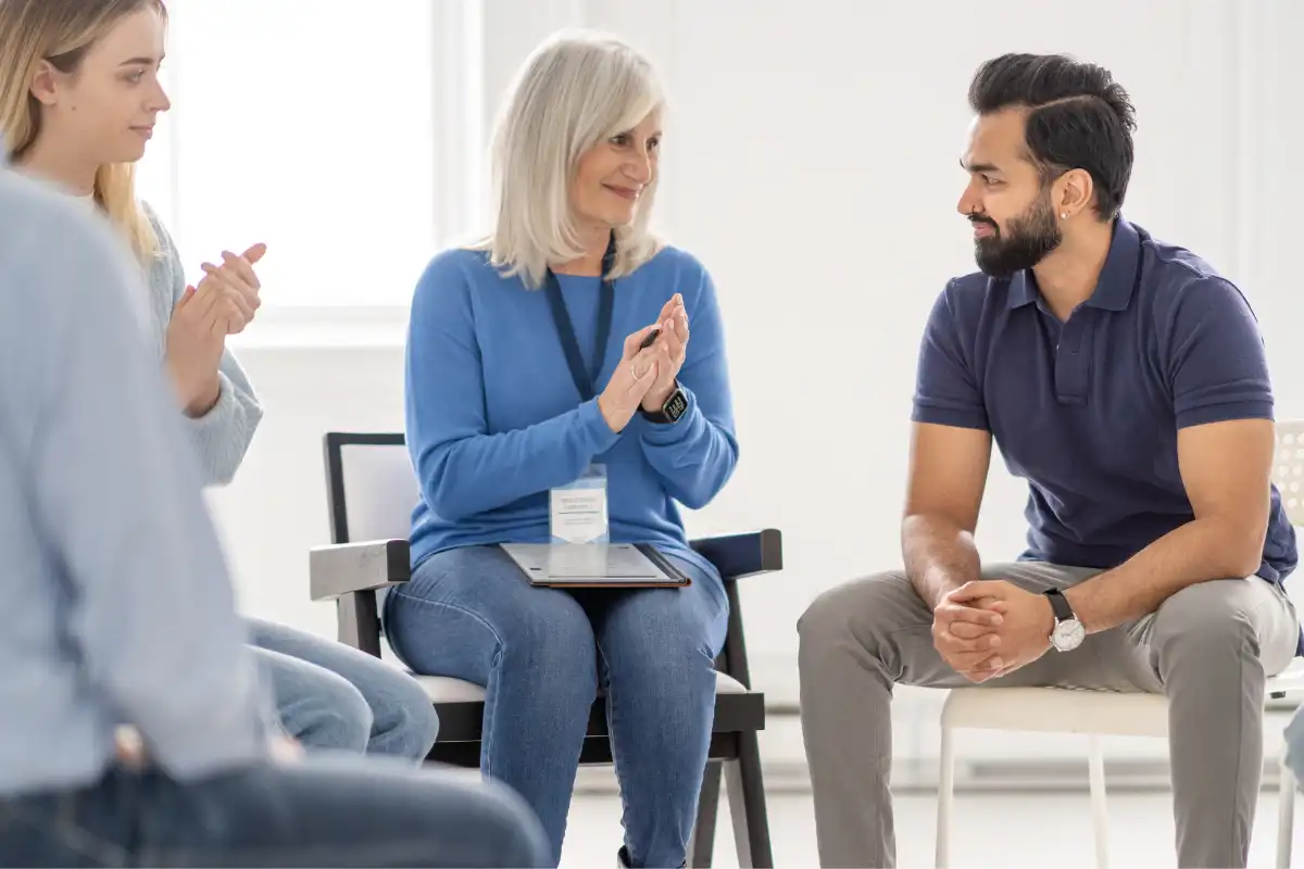 Group of people sitting in circle, talking during group therapy (1)