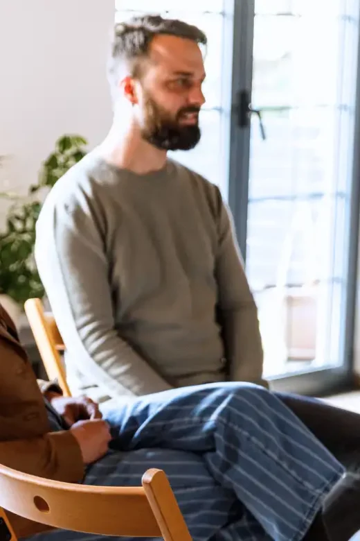 Group of people sitting in circle, talking during group therapy