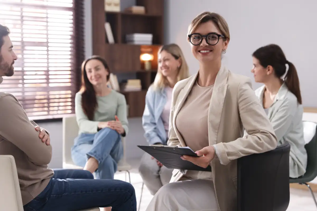 Professional Psychologist with Clipboard at Group Psychotherapy