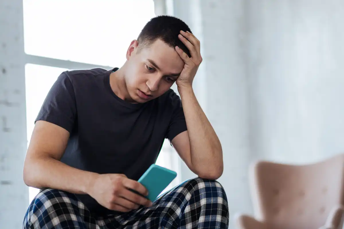 Sad man looking at his phone