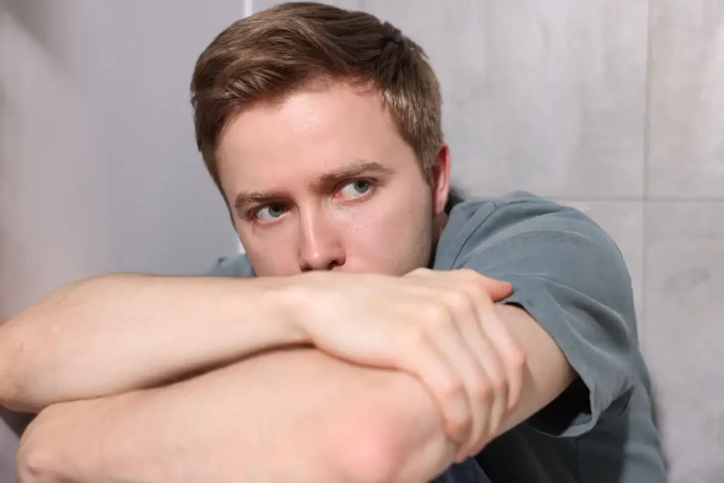 Scared Man Suffering from Paranoia at Home