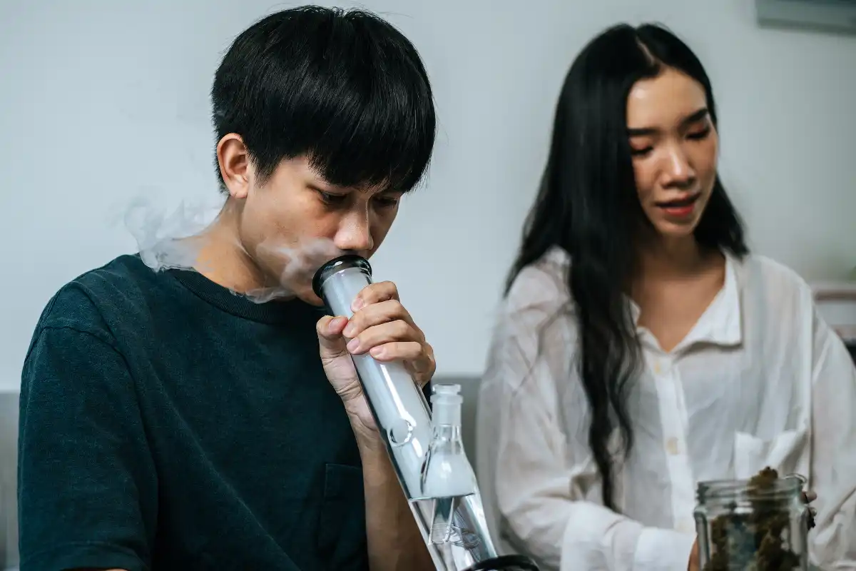 Young couple use hashish through glass to smoking marijuana