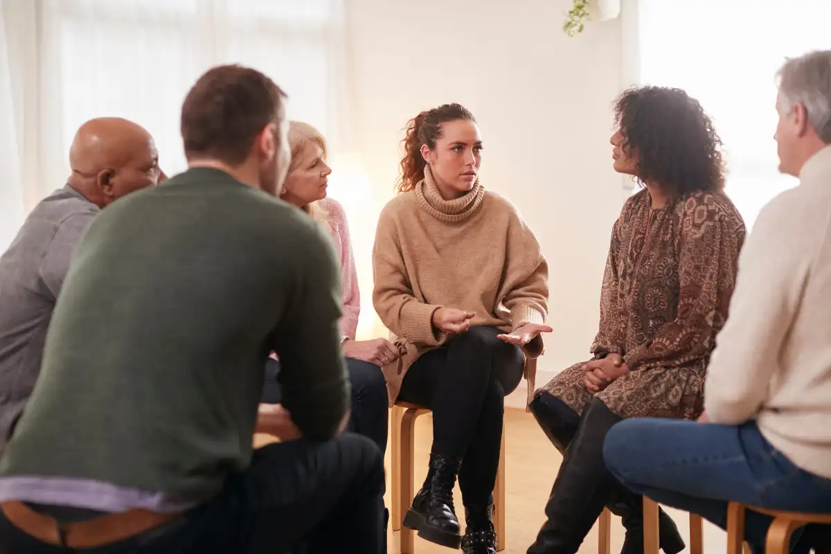 men and women during group therapy session at drug and alcohol treatment center