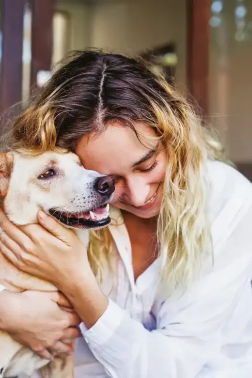 Beautiful caucasian woman hugging her mongrel dog pet