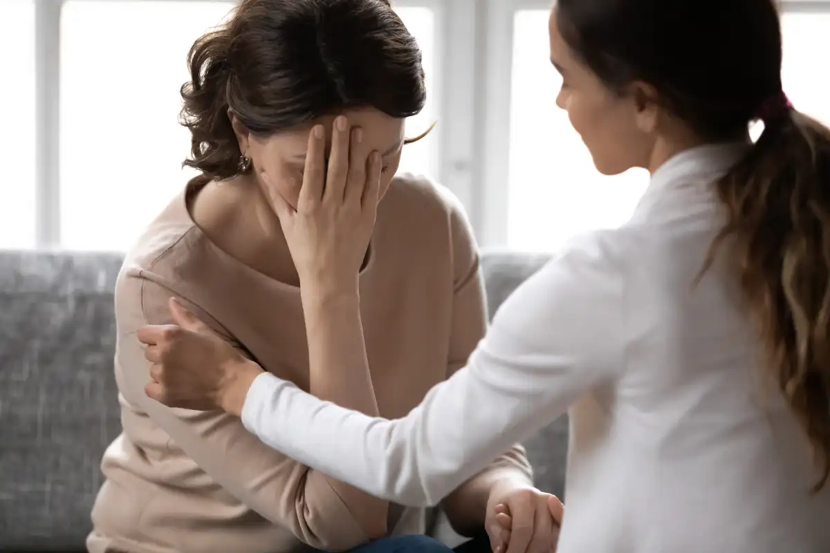 Compassionate kind young woman supporting depressed unhappy woman