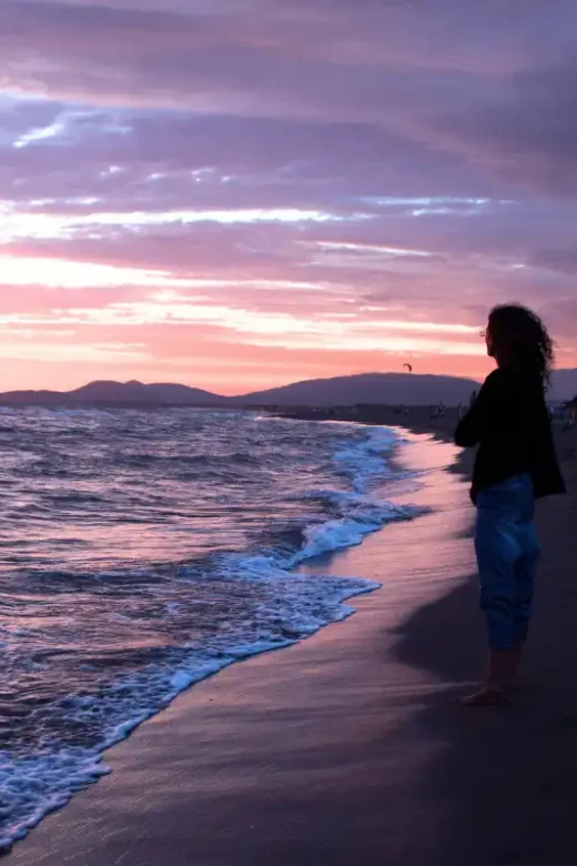 Woman Walking on Beach at Sunset