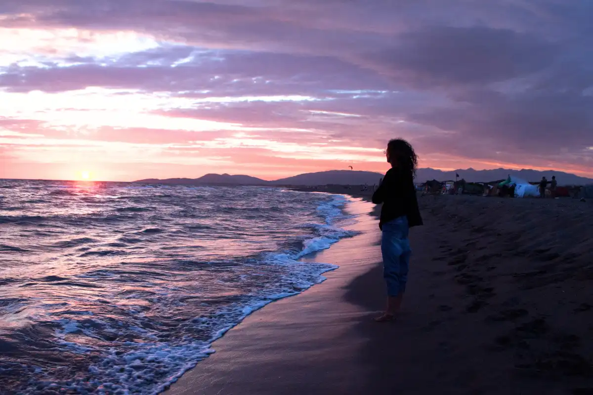 Woman Walking on Beach at Sunset