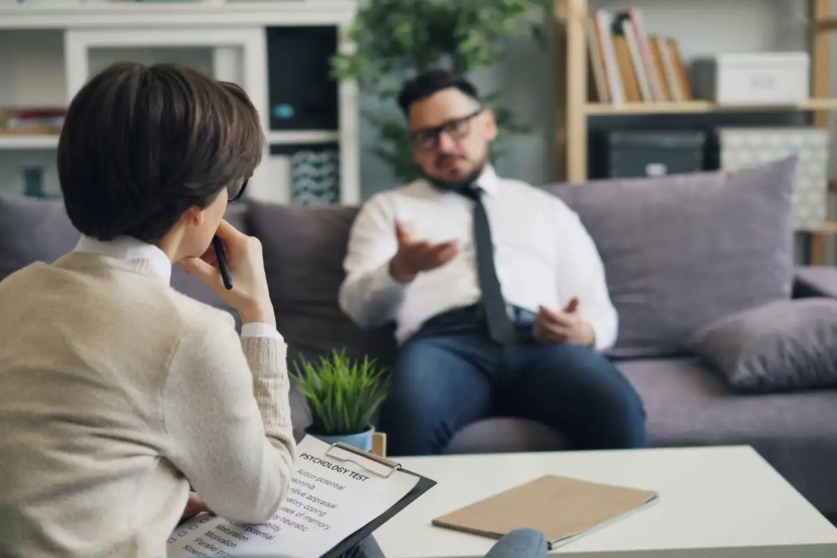 A man and a female psychologist sitting on a couch talking
