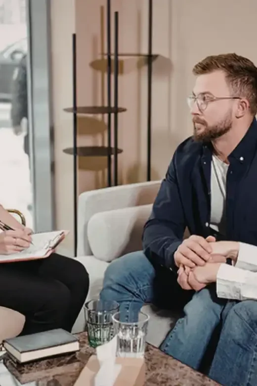Couple engaged in counseling session with therapist taking notes in modern office setting together