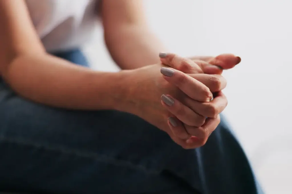 Hands, woman and nervous with anxiety for counseling session with emotional tension in therapy. Person, fidget and restless with stimming, trauma response and overwhelmed for psychology consultati (1)