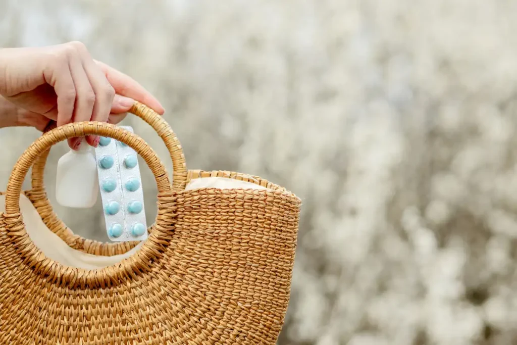 Woman putting medicine in her bag