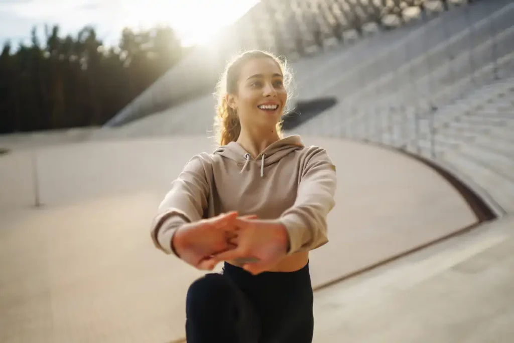 Young fitness woman exercising and stretching outdoors
