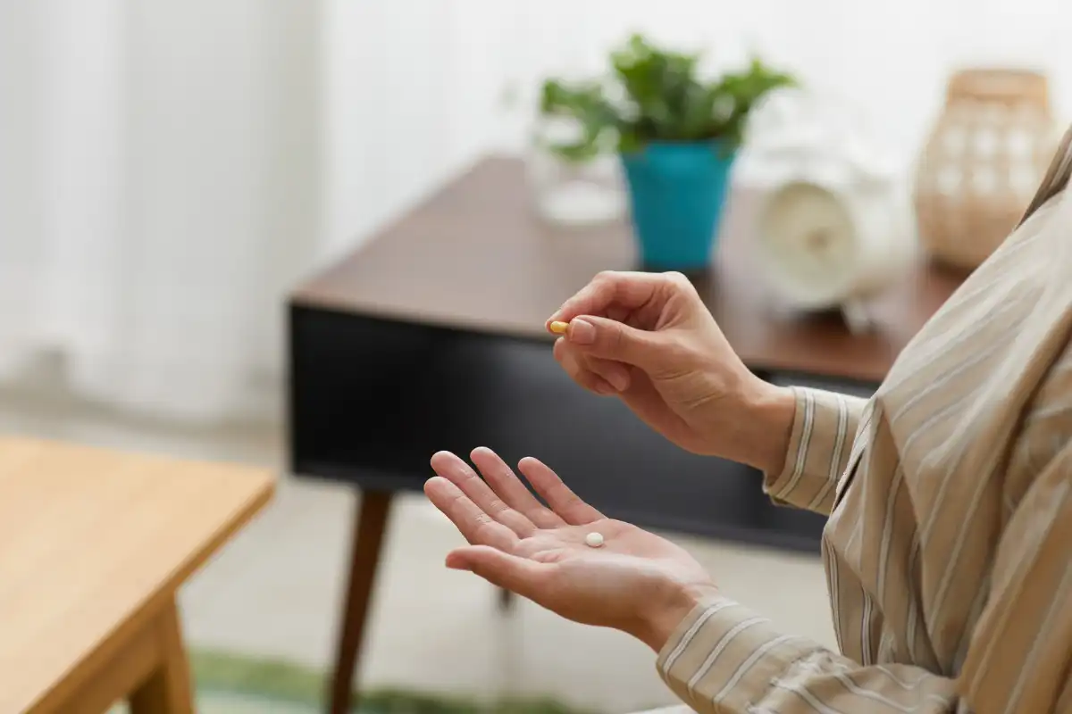 Woman with a pill and medicine tablet on her hands Factors That Affect the Withdrawal Timeline